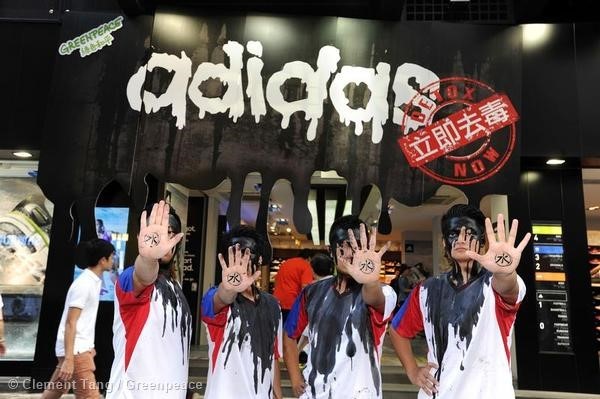 Greenpeace activists stand in front of a logo in the shape of 'dripping dirty water' outside the Adidas store in Mongkok, Hong Kong to protest and highlight the sports apparel giant's dirty secrets. The Global Day of Action is part of the campaign to remind Adidas of its environmental responsibility to clean up production of World Cup 2014 merchandise. Adidas, the official sponsor of the 2014 World Cup in Brazil, has introduced jersey, gloves, shoes and other products that contain a variety of toxic and hazardous substances. In addition, these toxic substances created harmful pollution caused by the manufacturing process in China, Indonesia and other countries.